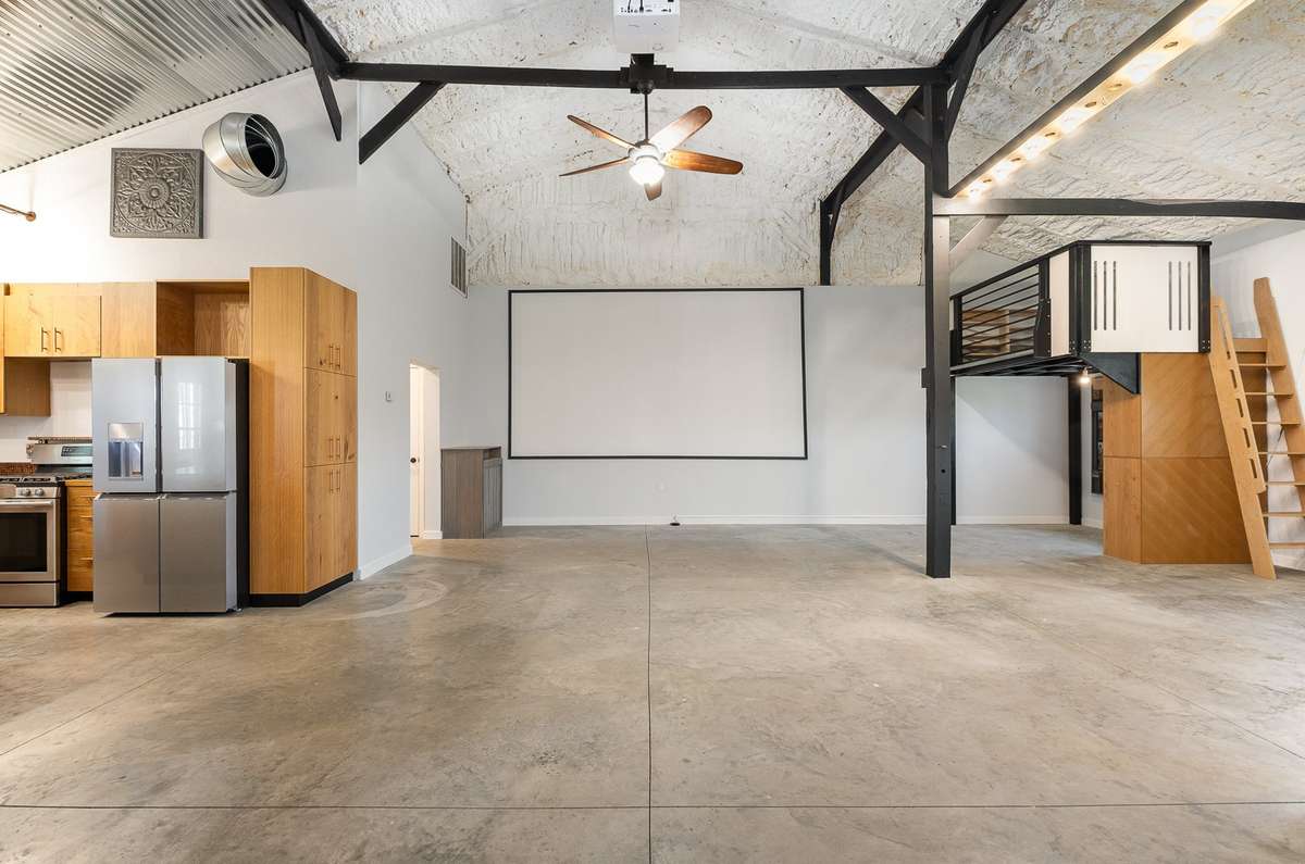 Here we see the open living area that the sellers used as a theater space.  The projector visible at the top of this photo is included in the sale.  The built in "nook" area on the right could be closed off to make another room.