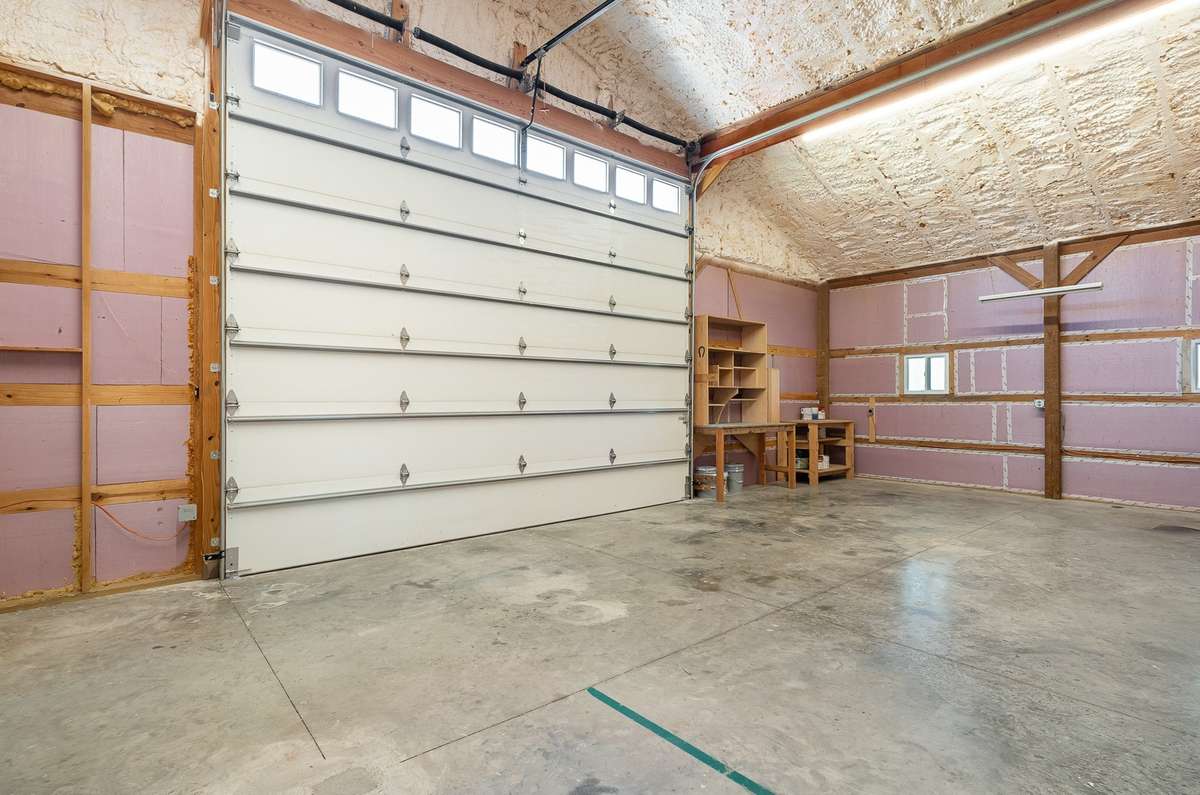 Secondary view of the attached garage / workshop showing the insulation that is already installed to help keep the area comfortable while you are utilizing the space.