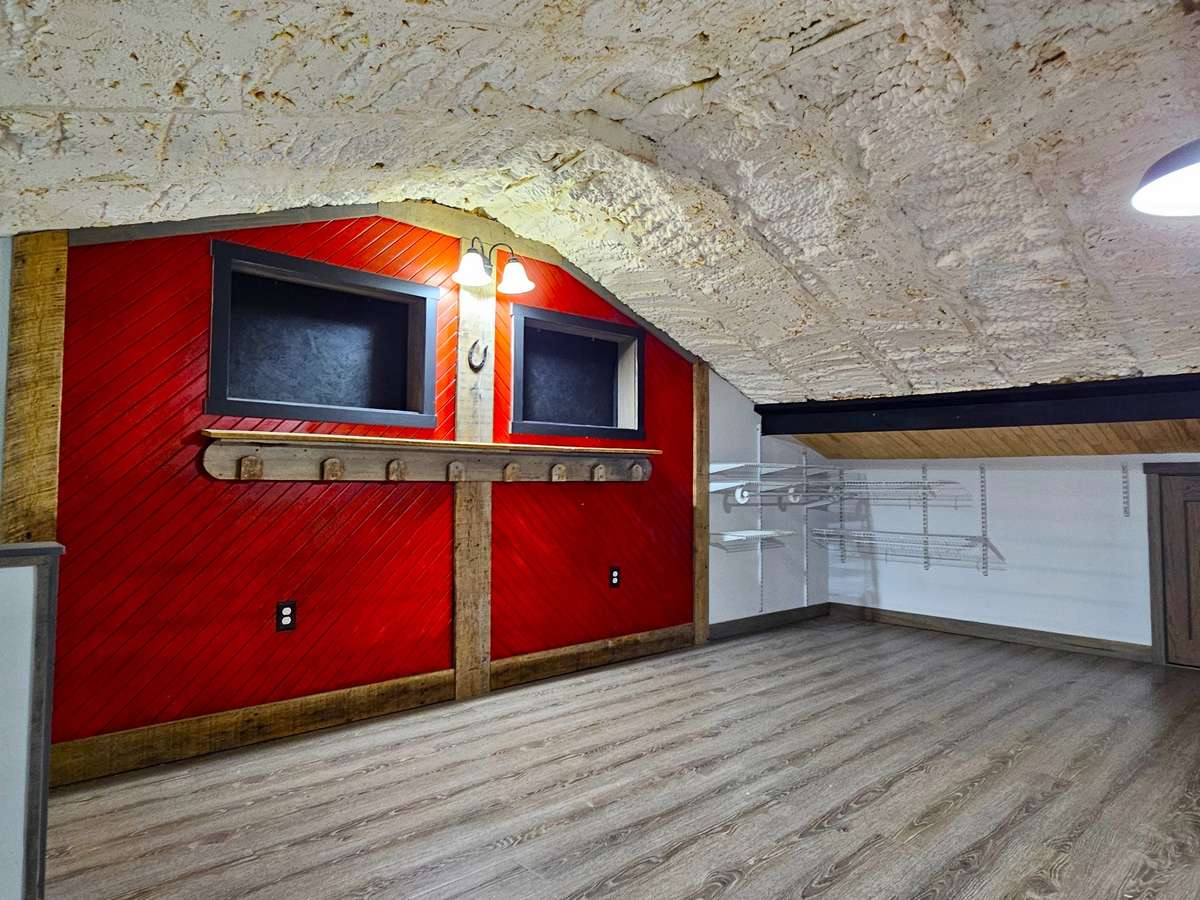 The loft area, located above the bedroom, would make an outstanding home office space and has shelving and additional storage in the small door to the right of this photo.