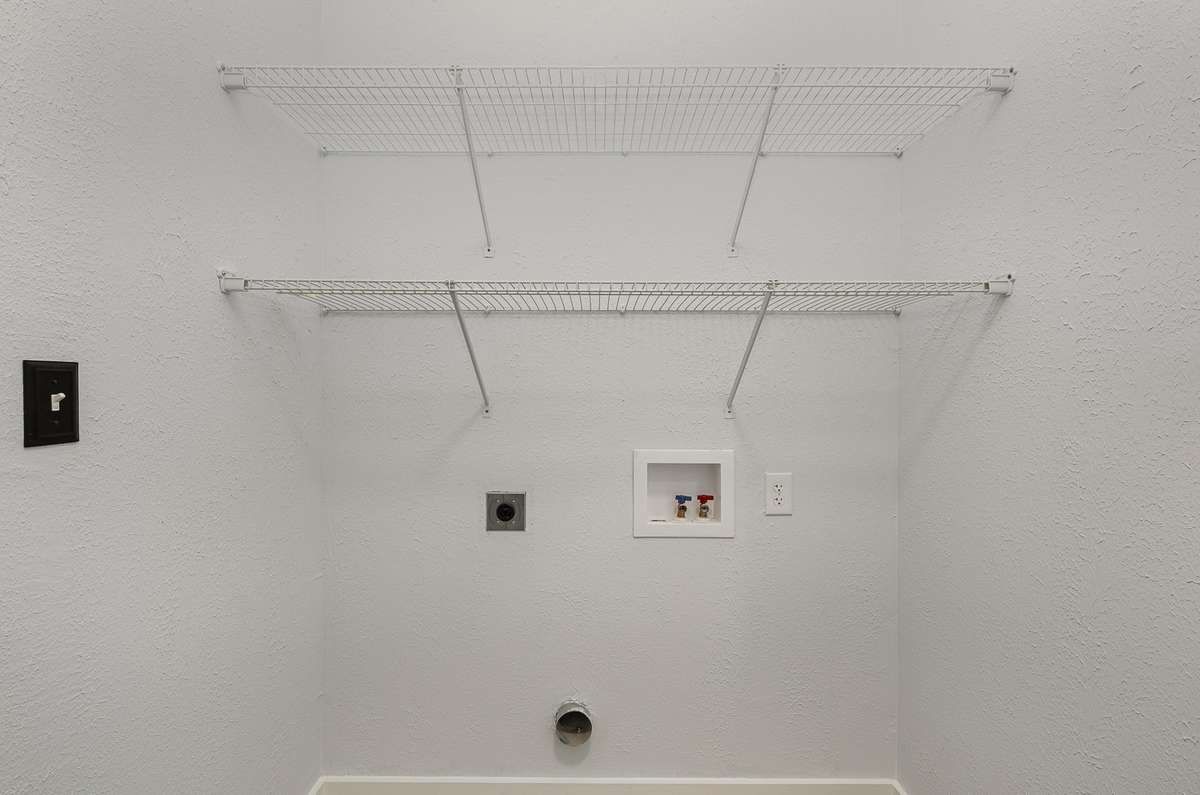 The utility room is located adjacent to the bathroom and holds a full size washer and dryer.