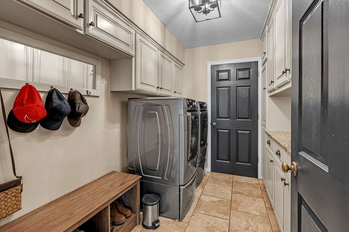 Laundry Room with entrance to garage and a drop zone with storage cabinets