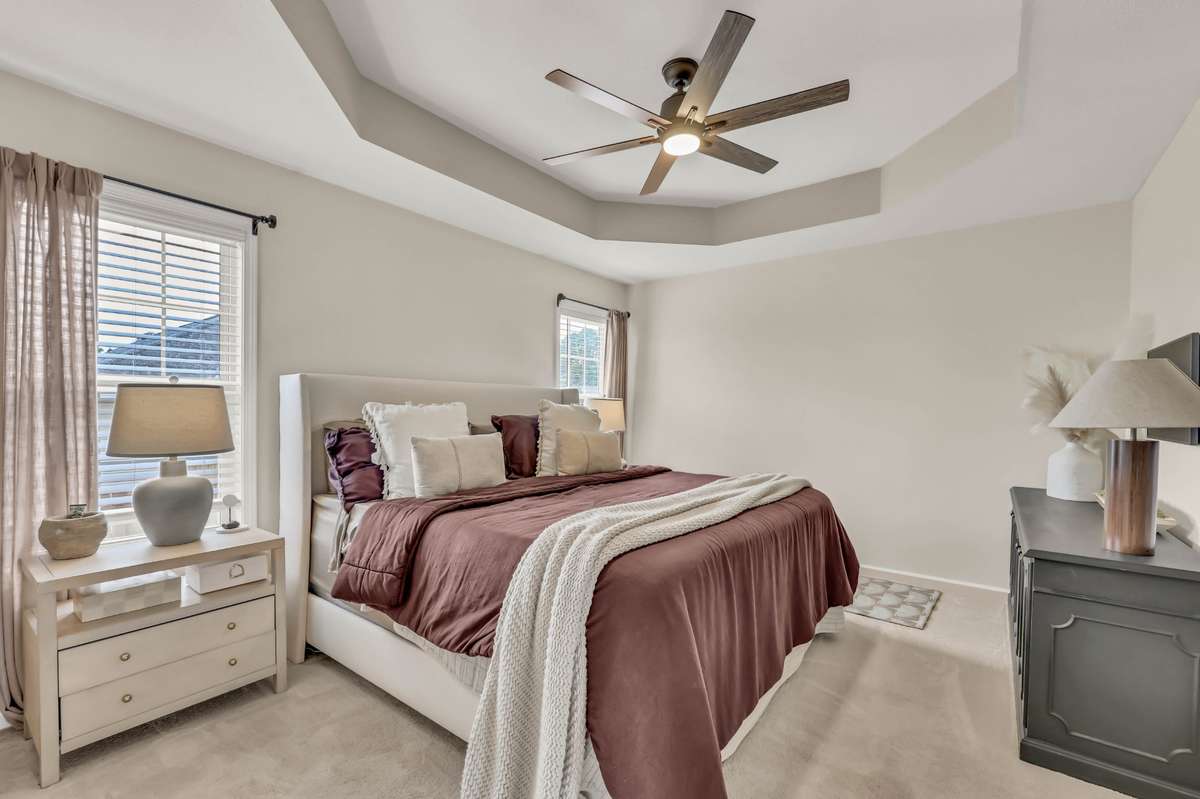 The primary suite features a tray ceiling + neutral paint
