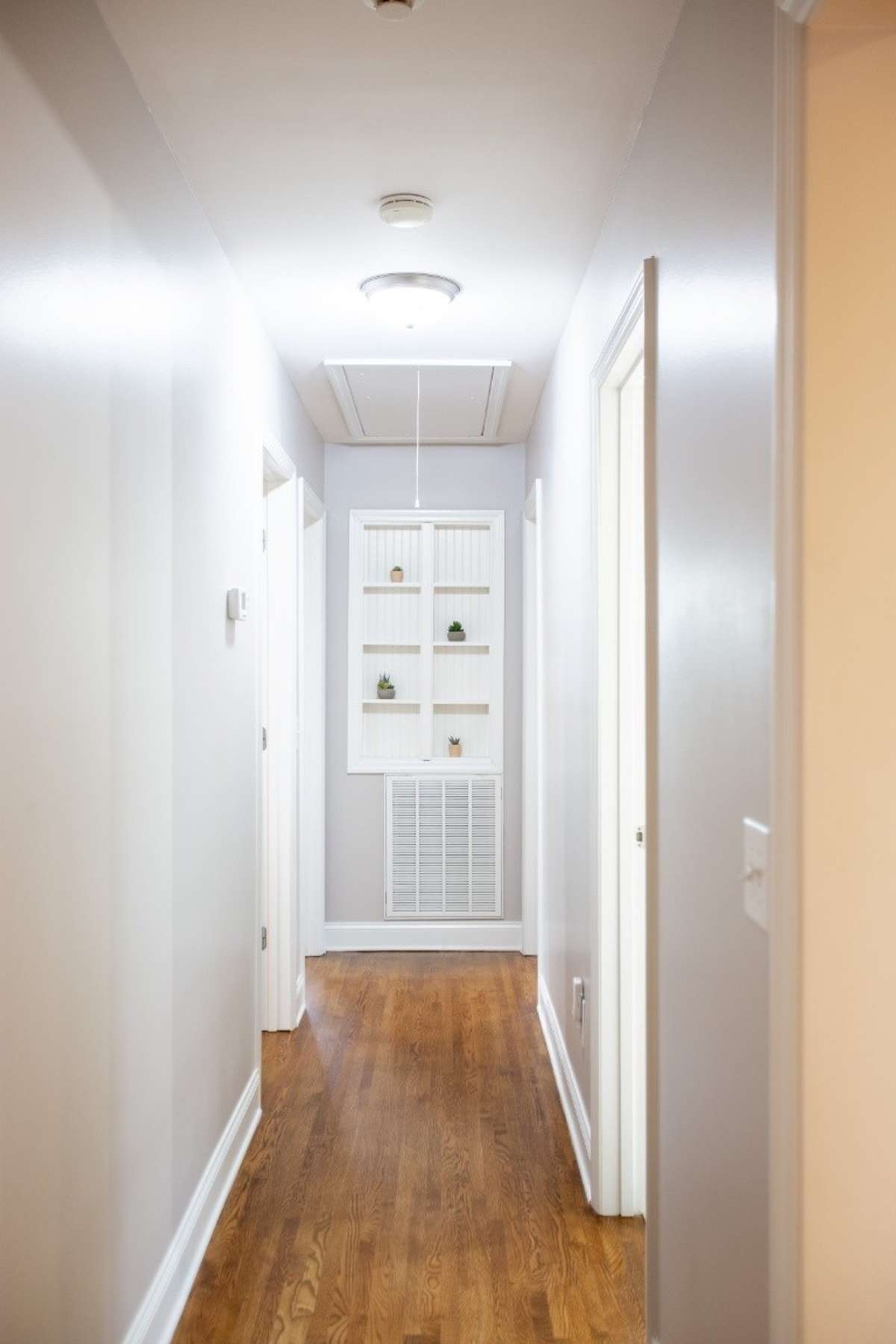 Hallway to 4 bedrooms and bath has a hidden gem at the end of the hallway. All your security equipment can be kept behind the bookshelves!