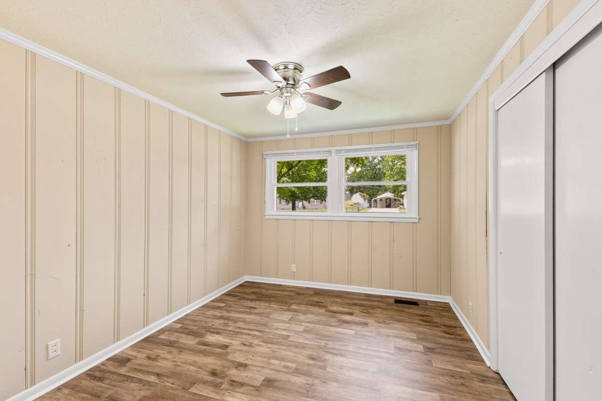 Bedroom one on the front of the home with painted paneling.