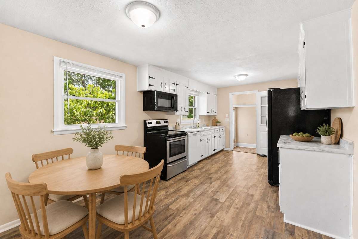 Just behind the living room is the eat-in kitchen. Virtually staged to include the dining table.