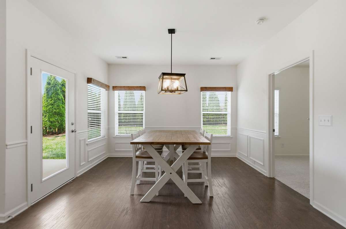 The dining room has tasteful wainscoting and opens onto the back covered patio.