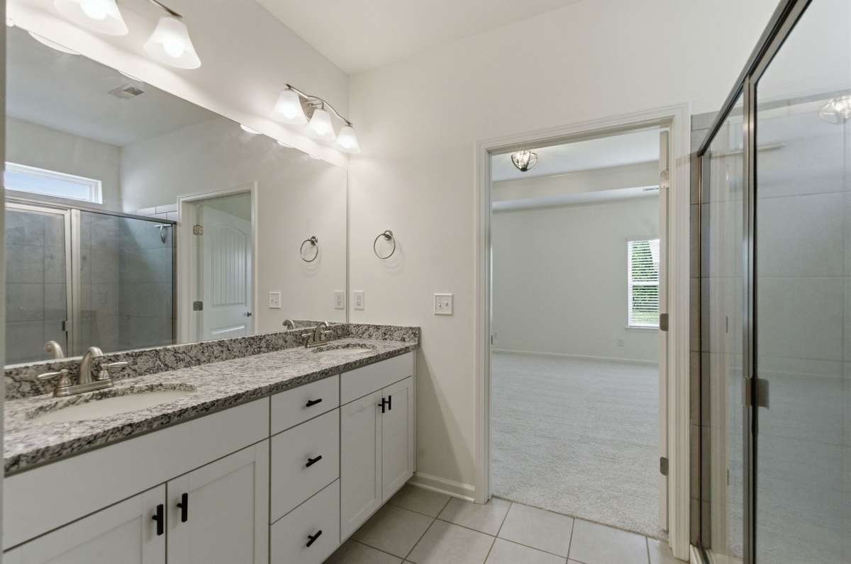 Primary ensuite bath has double vanity and plenty of light.