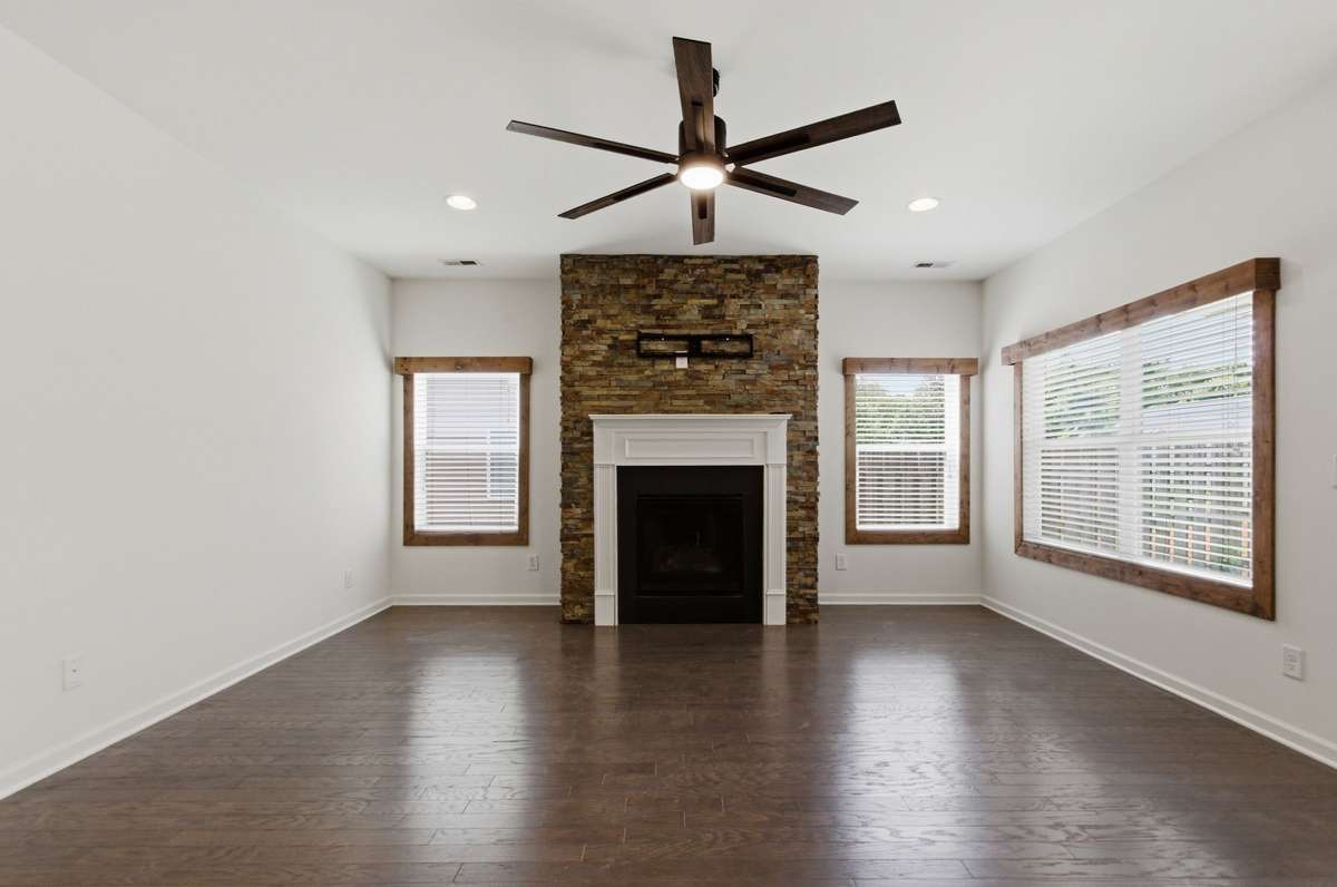 This home has nice architectural details, like the natural wood window frames and sills, and stacked stone fireplace surround.