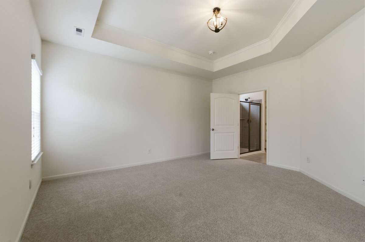 A view of the primary bedroom leading into the ensuite bath.