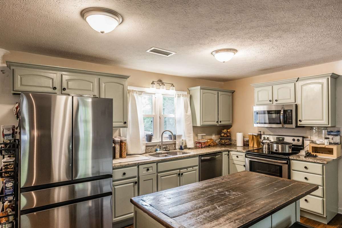 Granite countertops, new stainless steel appliances, and island.  Separate room with washer/dryer and tankless water heater not shown in pictures, but offers additional storage.