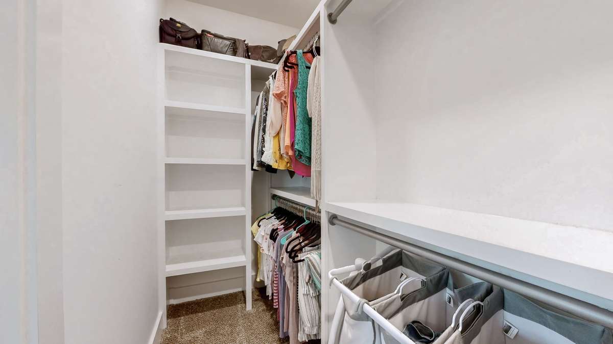Primary Suite walk-in closet with custom shoe storage, floor to ceiling storage
