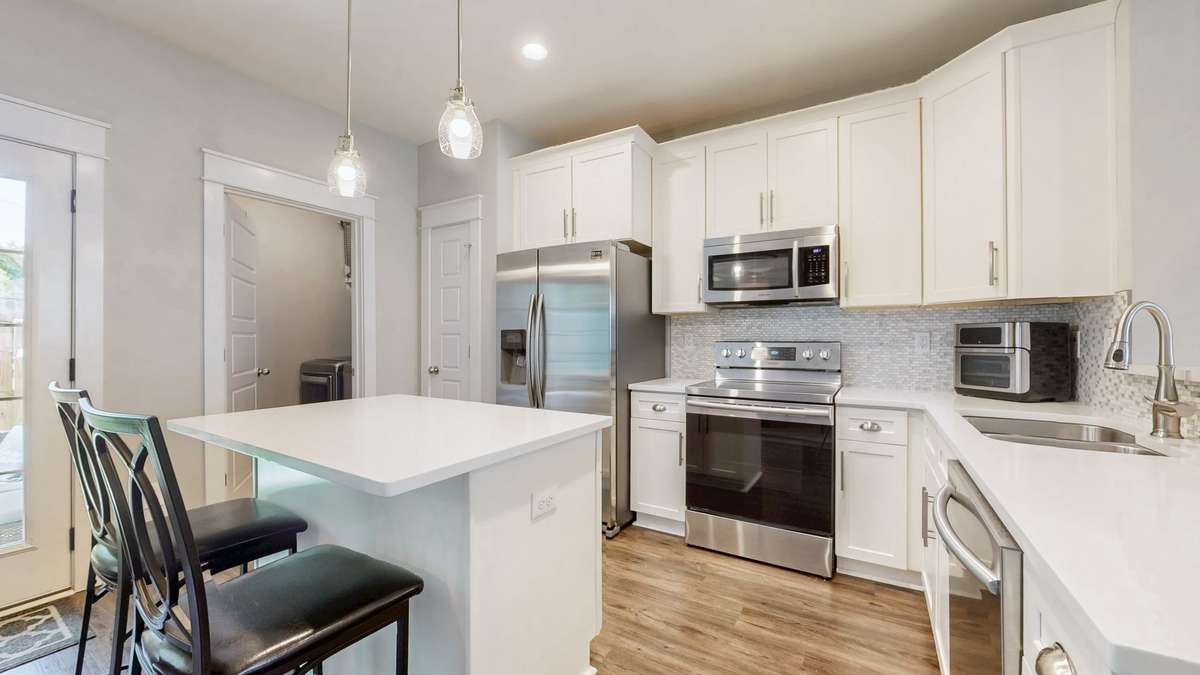 Kitchen & pantry with access to utility room with washer/dryer and custom shelving.