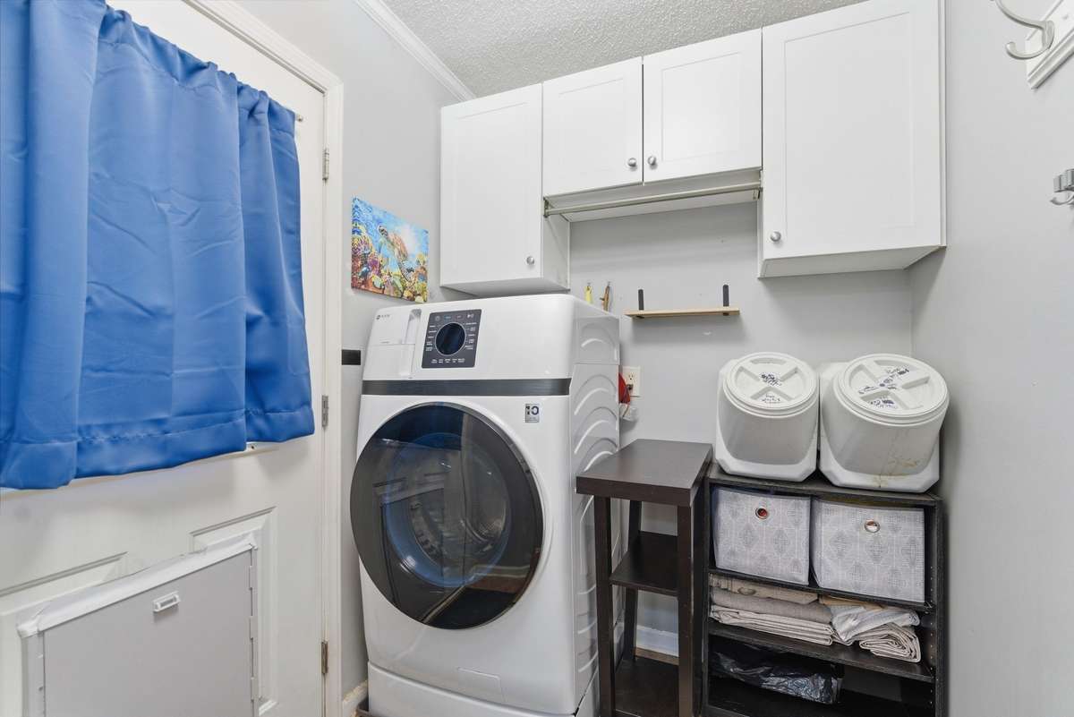 Laundry area off of the kitchen w/ cabinetry. Back door leads to sunroom addition w/ mini split unit! Door has smart locks, as well. (W/D does not remain.)