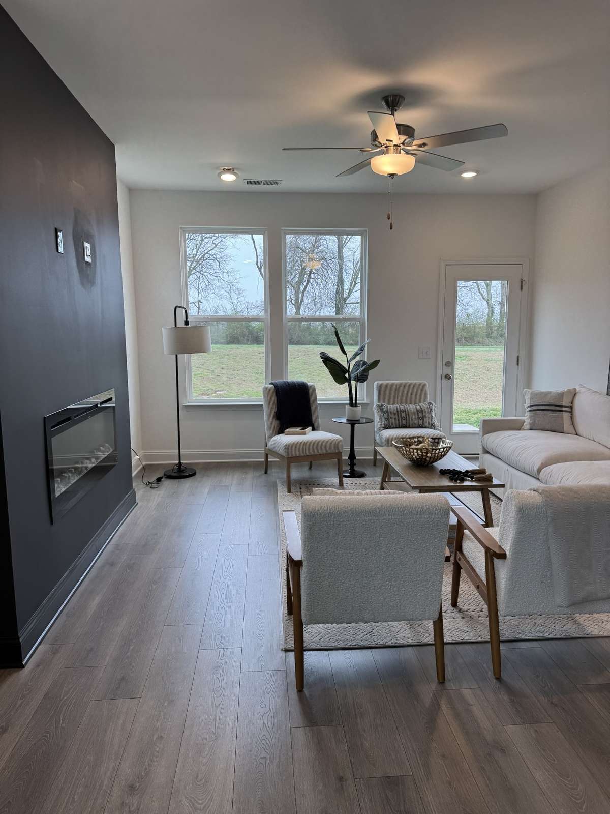 The living room area looks out to common space and the neighborhood walking trail