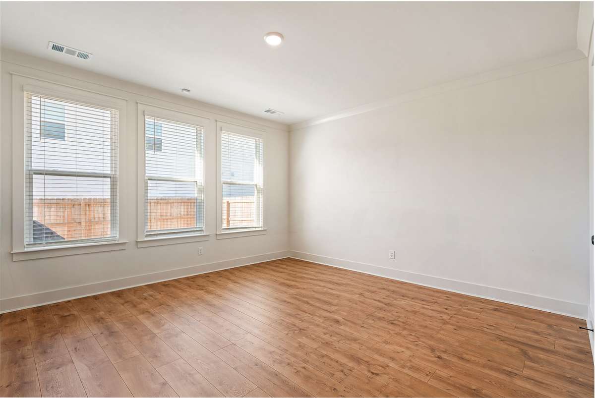 Primary bedroom features hardwoods and large for a king size bed, side tables, and extra furniture.