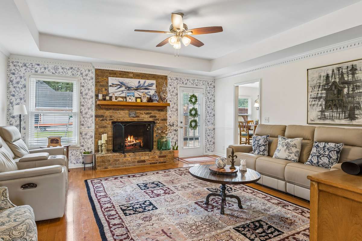 Spacious great room has a trey ceiling with fan and brick fireplace and more of the timeless hardwood flooring! 2104 Red Mile Rd, Murfreesboro, TN 37127