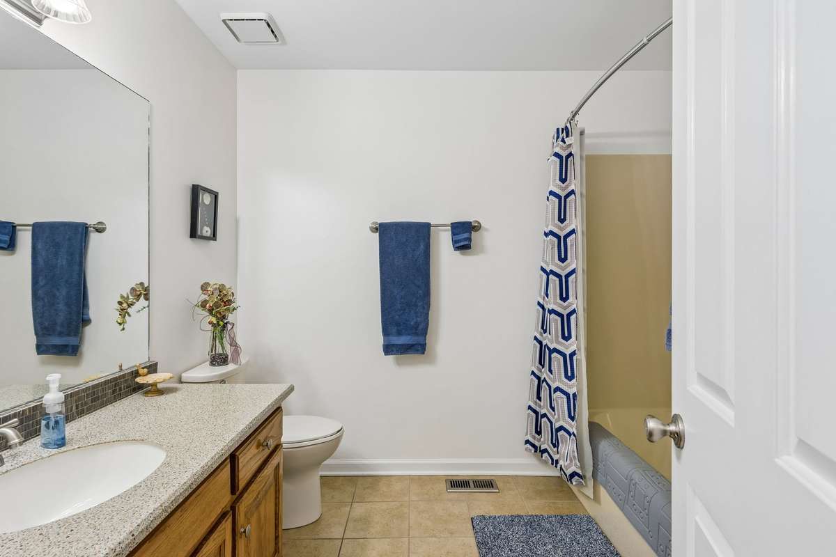 Large guest bath has tile floor and an oversized vanity. 2104 Red Mile Rd, Murfreesboro, TN 37127