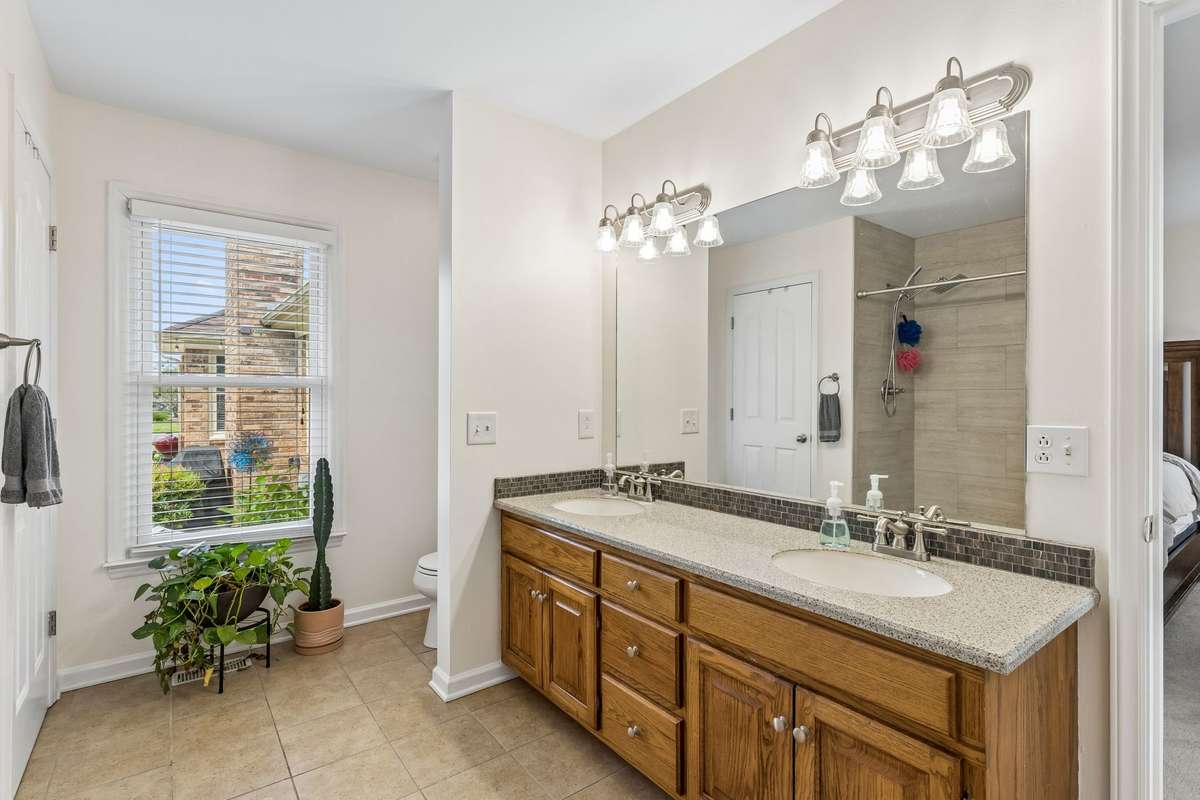 Primary bath has a double vanity, natural light, and tiled floor. 2104 Red Mile Rd, Murfreesboro, TN 37127