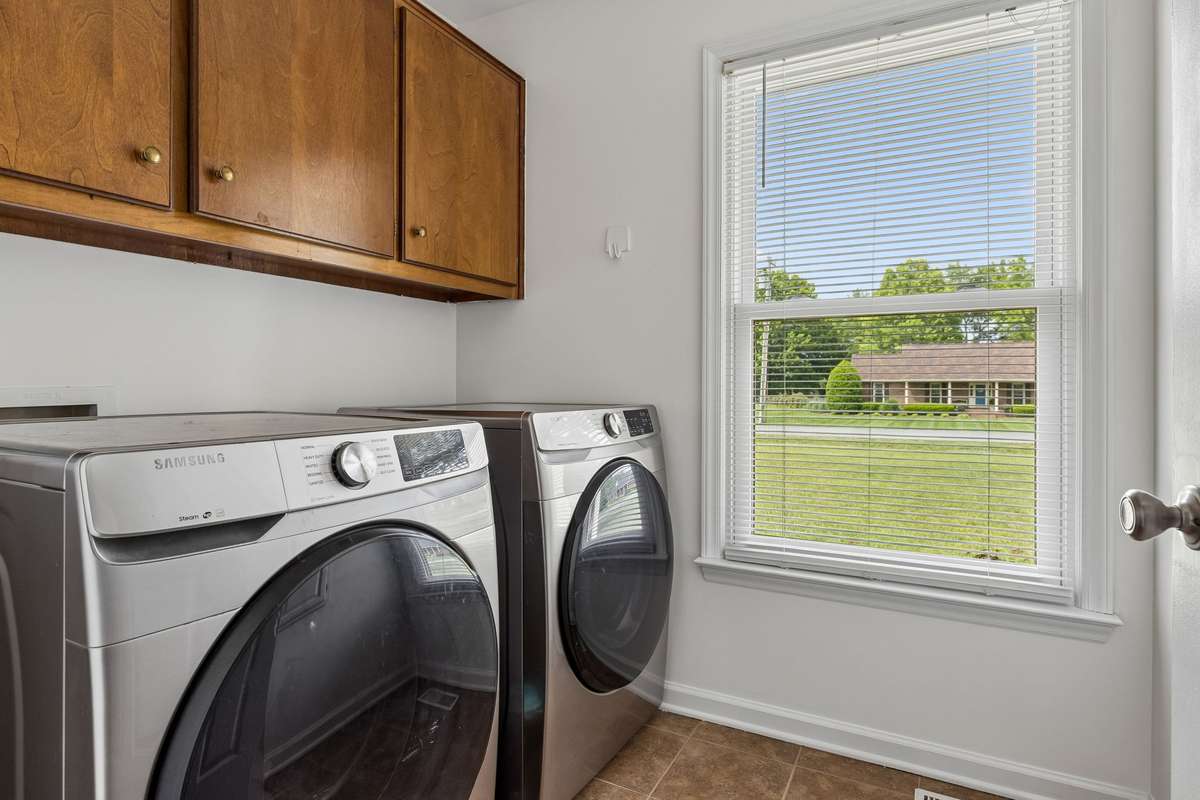 Laundry room with tile floor and cabinetry for storage. 2104 Red Mile Rd, Murfreesboro, TN 37127