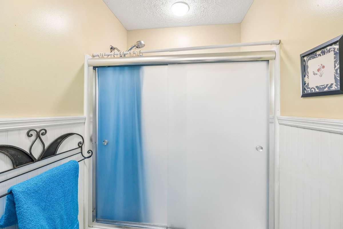 The other portion of the full Bath with combo tub/shower and commode. This area has wainscotting on the walls.