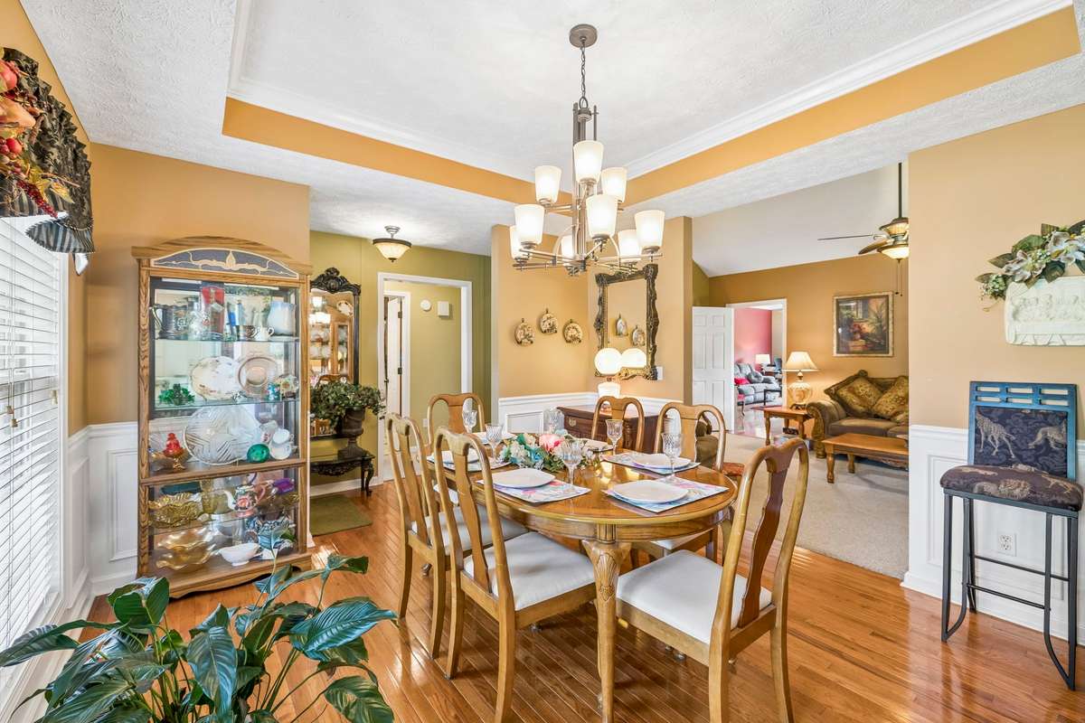 The formal Dining Room with a trey ceiling and gorgeous gleaming finished hardwood flooring!