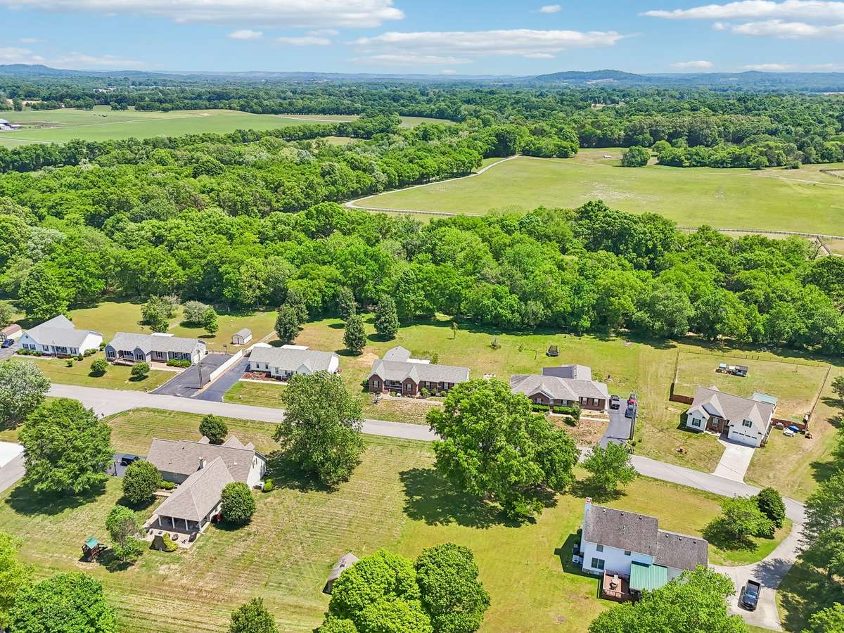 In this drone view of the area, the home is the 4th from left, 3rd from right with the woods/creek in the back.