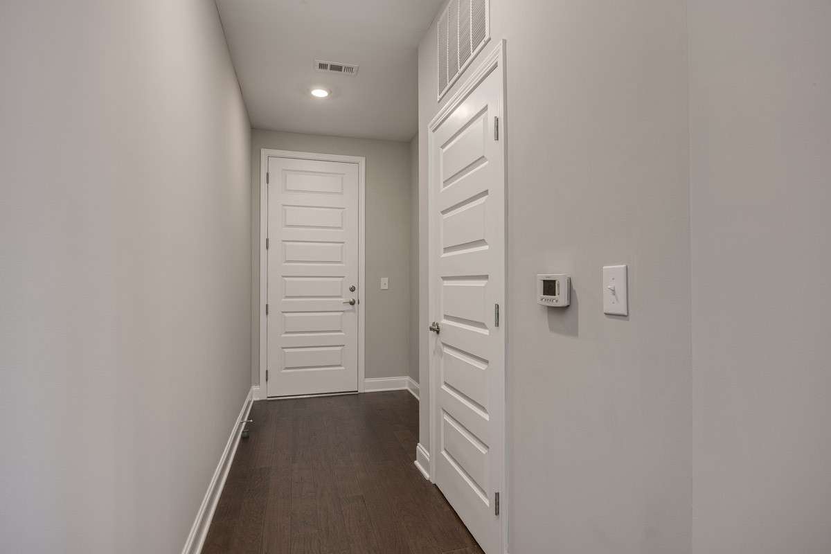 Hallway to front door with utility closet