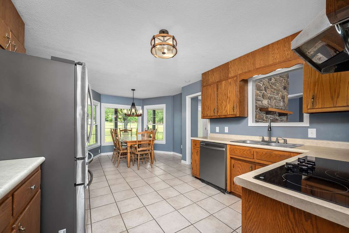 The kitchen is well appointed with stainless appliances and tiled floor.