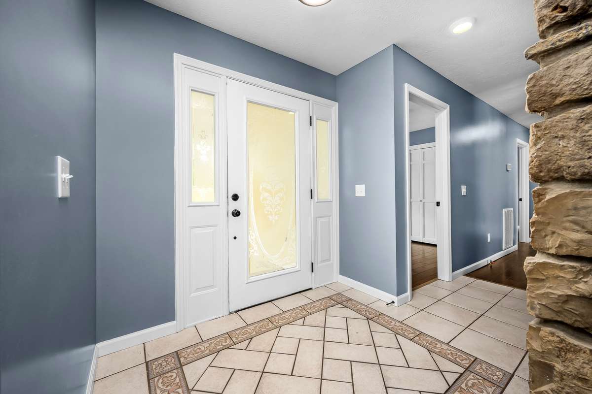 Just inside the front door you are greeted by this entry foyer area complete with lots of natural light, tiled floor and rock fireplace.