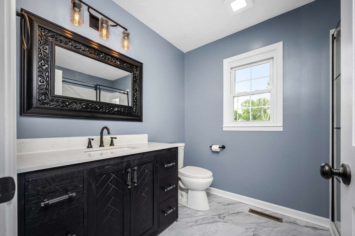 The ensuite primary bathroom has been updated with new vanity, lighting, new toilet, flooring and shower.