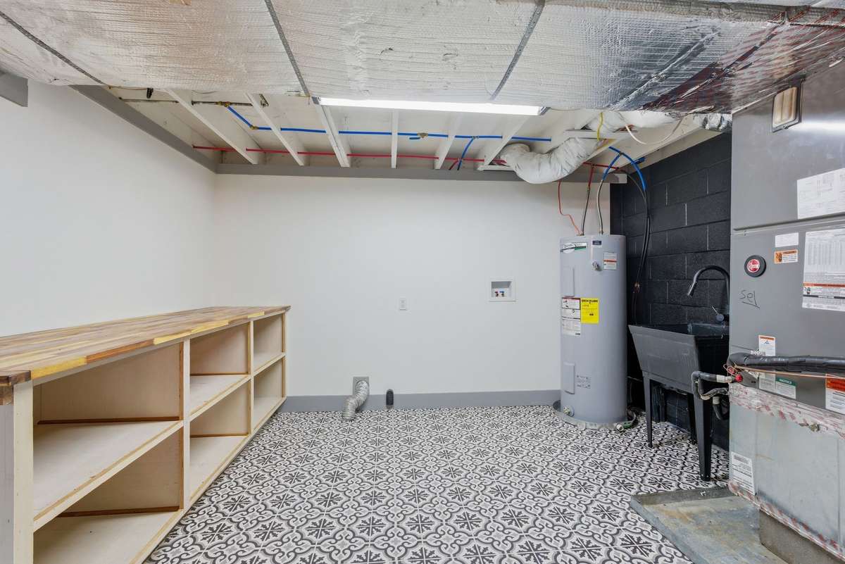 Utility room with washer dryer hookups, built in counter and storage space, and sink