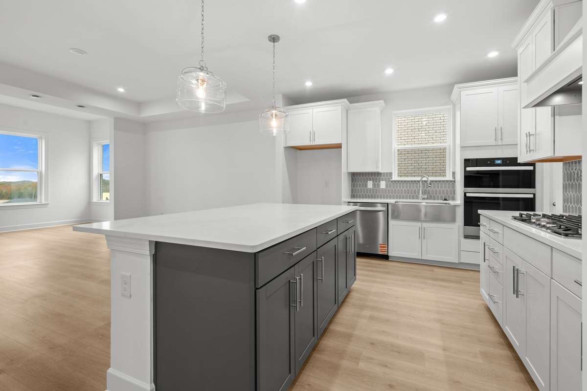 Enhanced kitchen with gas cooktop, micro/oven combo and beautiful wood vent hood.