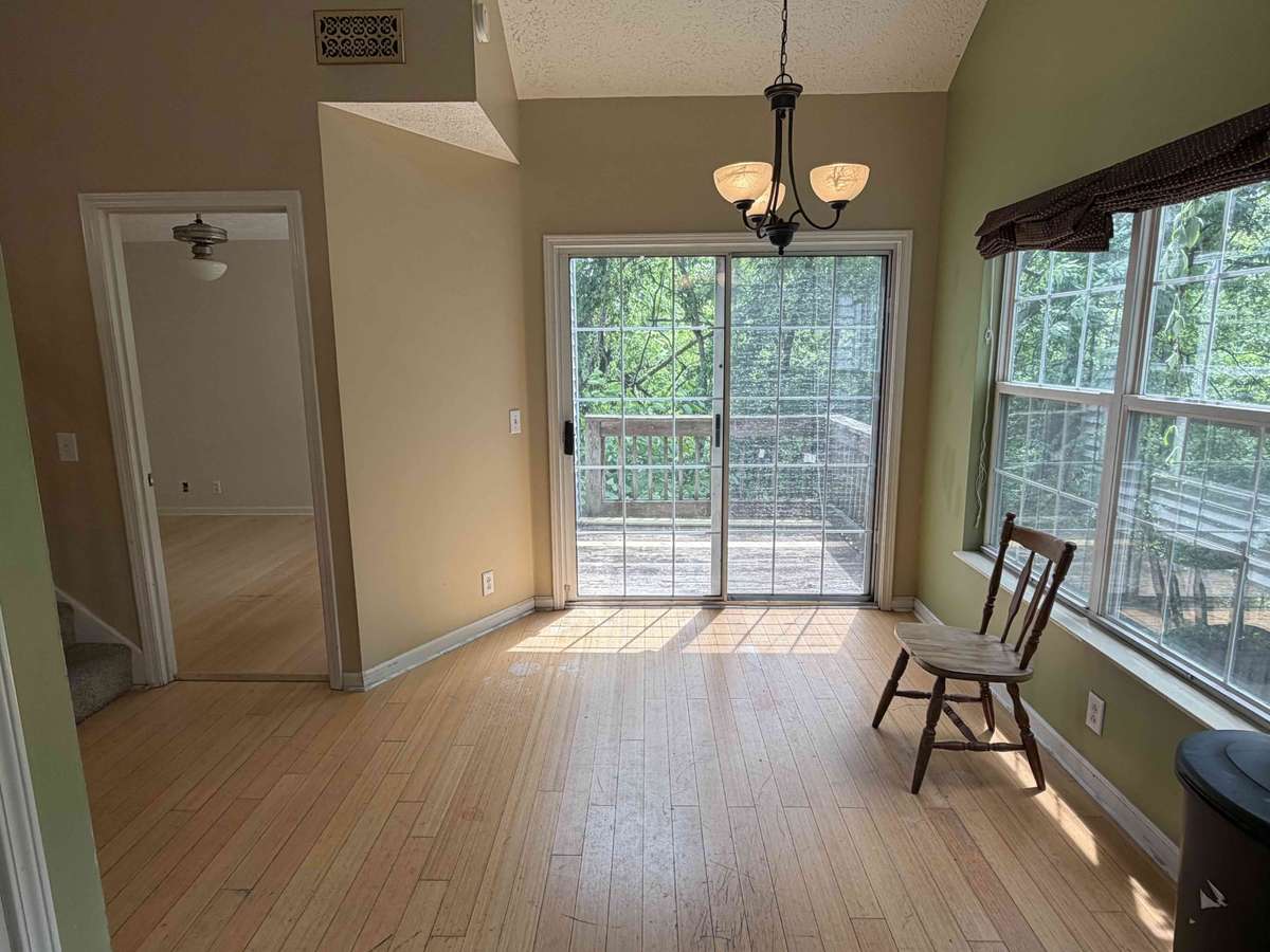 Functional kitchen with white cabinetry, tile flooring, and eat-in area with natural light from nearby windows.