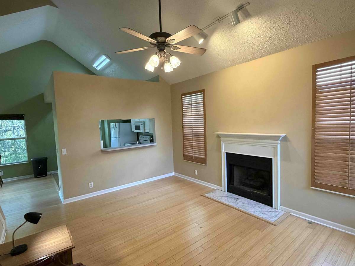Alternate view of the main living area showcasing the open layout, fireplace, and pass-through to the kitchen, creating an easy flow for everyday living.