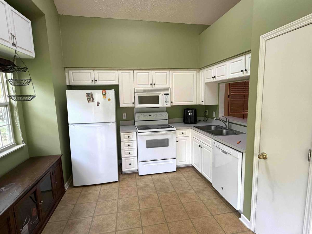 Functional kitchen with ample cabinet space, tile flooring, and an eat-in area. Layout offers a great opportunity to update and customize to your style.