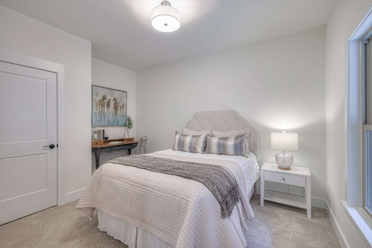 **Photos of the model home secondary bedroom on the main level to show the layout of the floor plan staged with furniture. Not the actual house.**