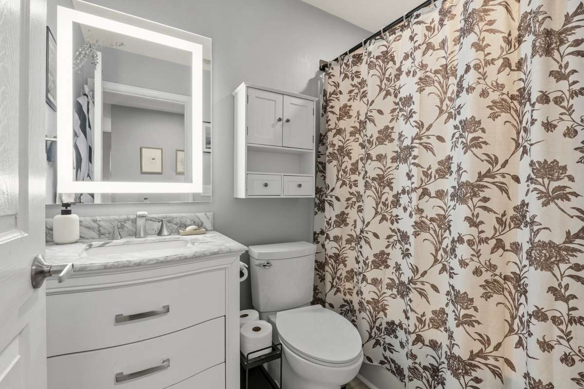 Full hallway bathroom with vanity and tub/shower combo