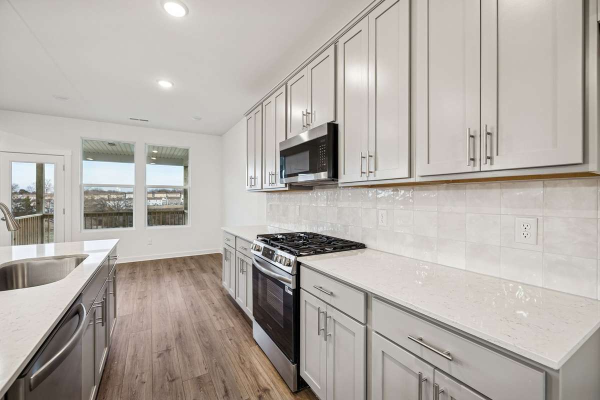 Picture of model home and not of actual home being built.  Kitchen will have beautiful tall light gray cabinets, tile backsplash, and stainless appliances with gas stove.