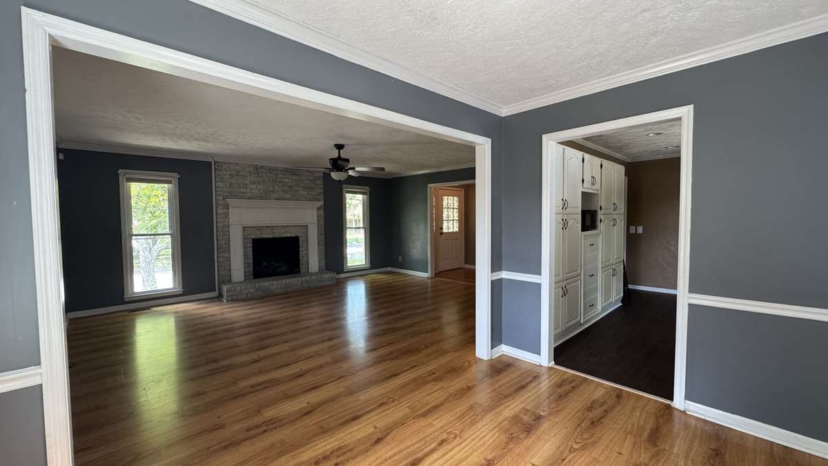 Picture took from dining area looking into large living room.  Beautiful brick gas log fireplace with mantle accents this area !