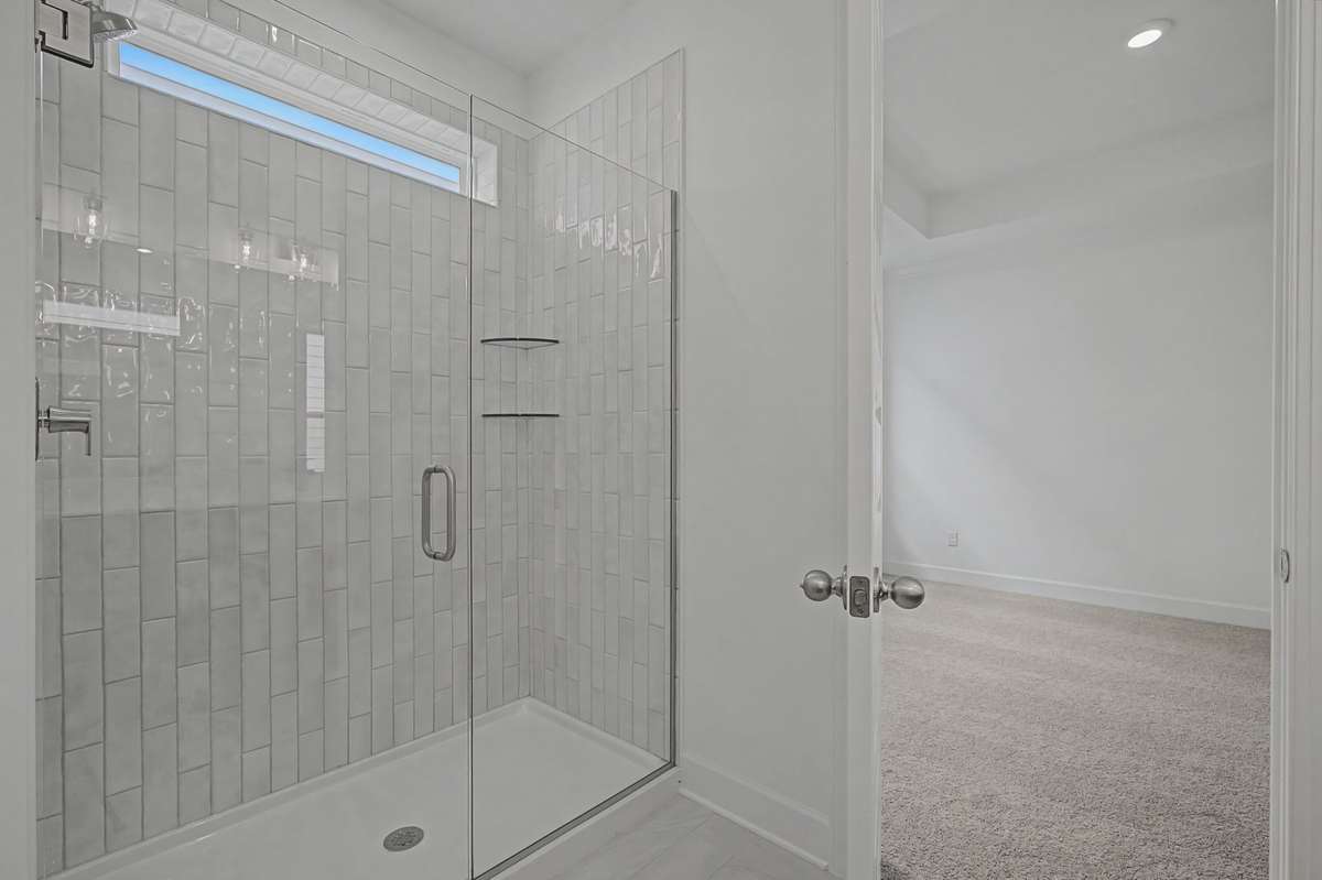 Overside shower and frameless glass elevate this primary bathroom!