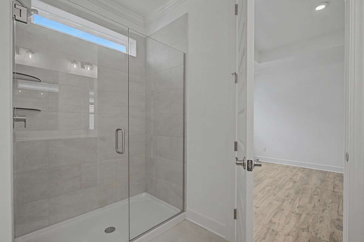 Oversized shower and frameless glass elevate the en suite.
