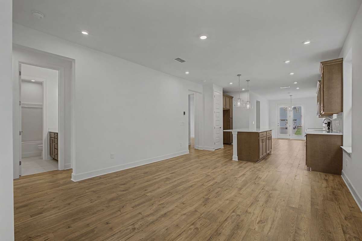 Open concept living room, kitchen and dining nook in rear.