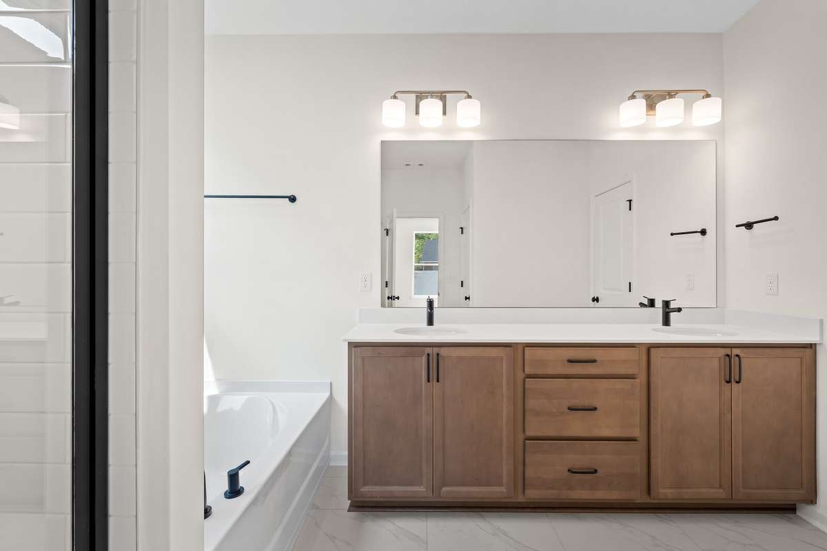 Beautiful stained double vanity, upgraded tile flooring and a tiled shower in the Primary Bathroom