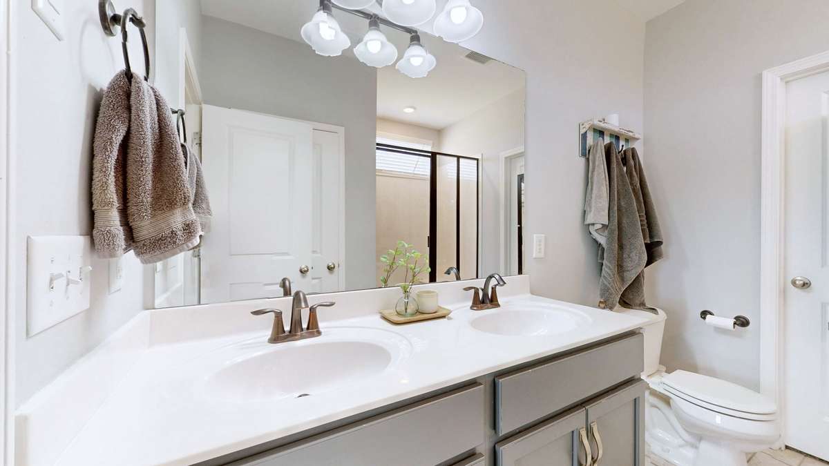 Primary bath with double vanity and large closet.