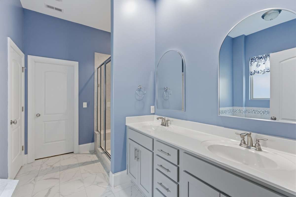 Master bathroom with double vanity, a garden tub, a walk-in shower, and a spacious closet.