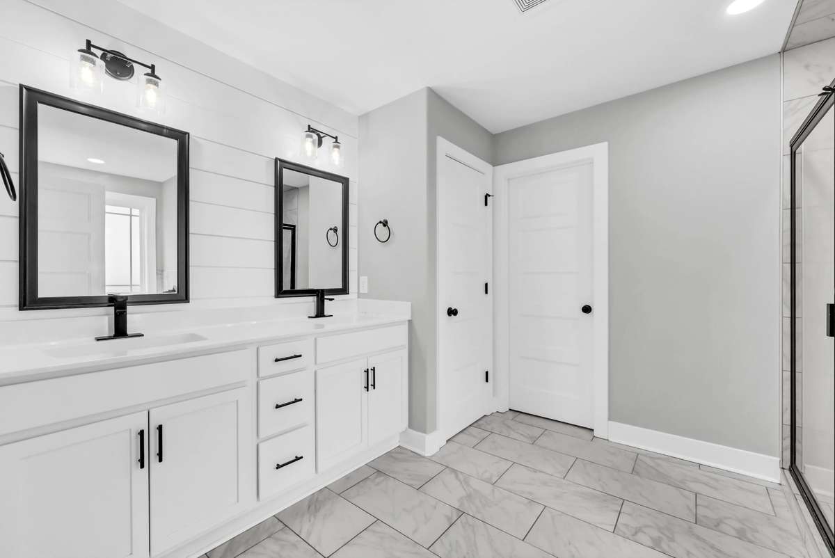 A double vanity, shiplap wall detail, and a handy linen closet complete the space.