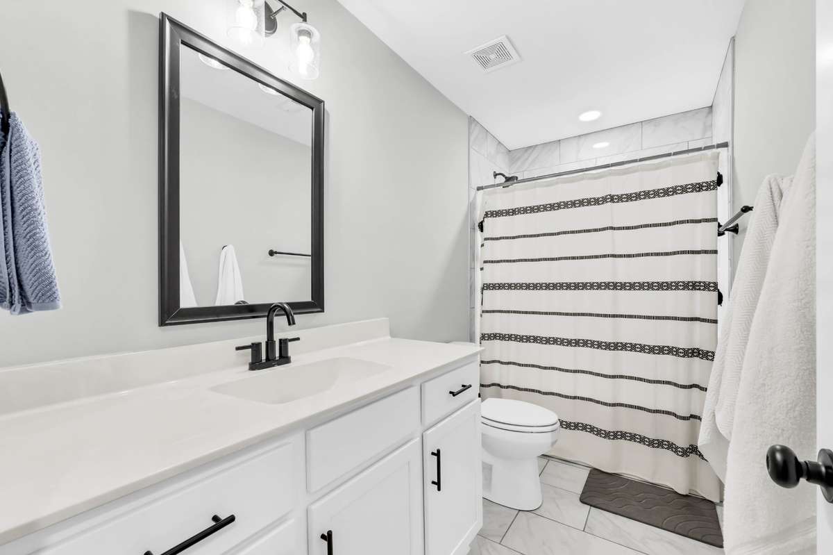 The shared hall bath features durable tile flooring.