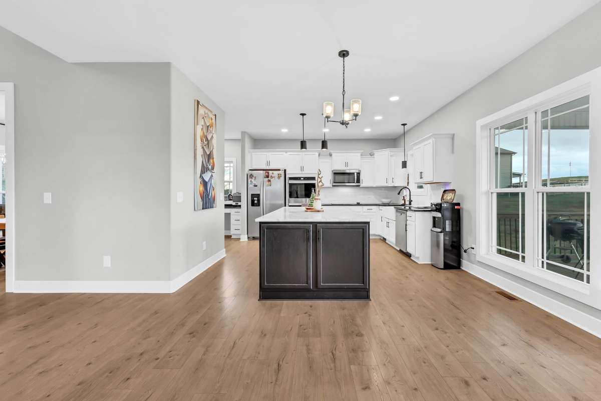 Open inviting kitchen area with extra long island perfect for barstools & entertaining