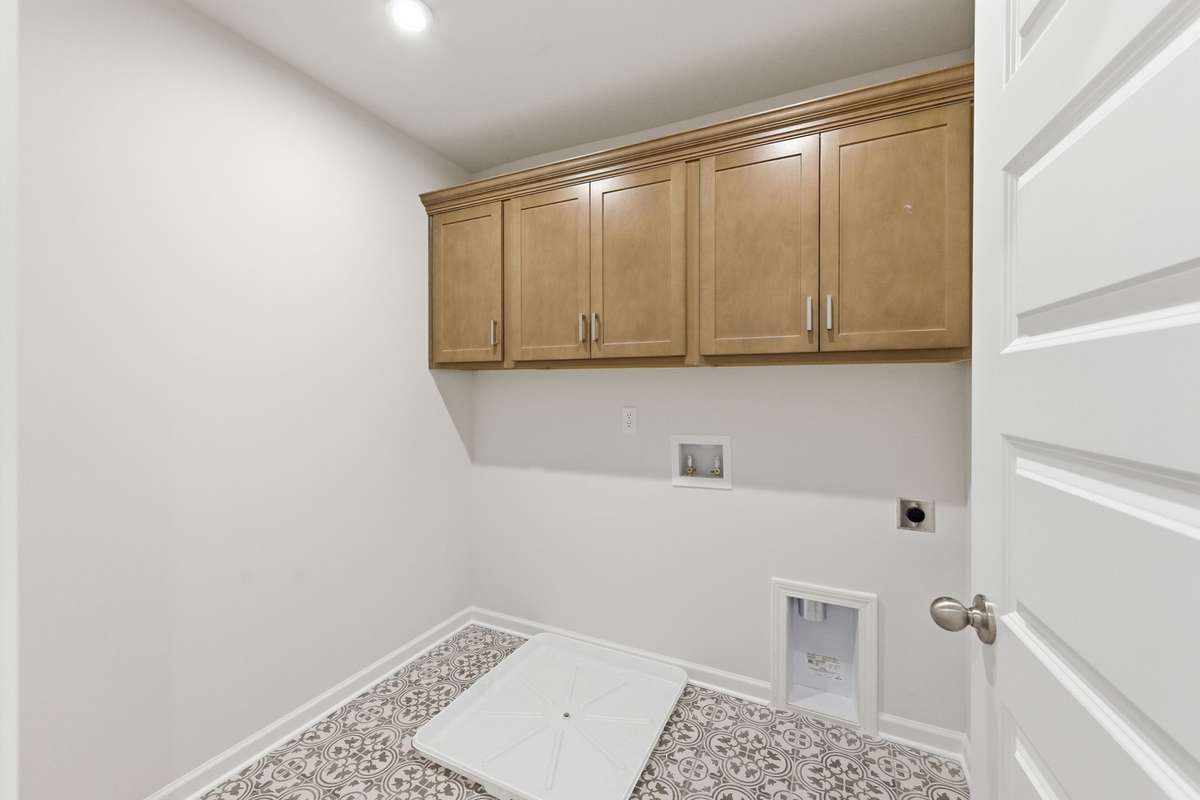 The perfect laundry space with cabinets and tile flooring.