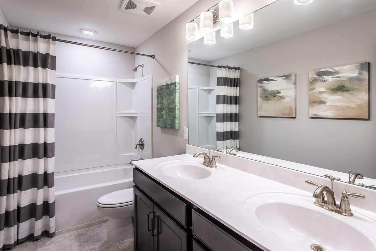 Double vanities in your guest bathroom upstairs. Tiled shower optional. *All photos are of previous model home*